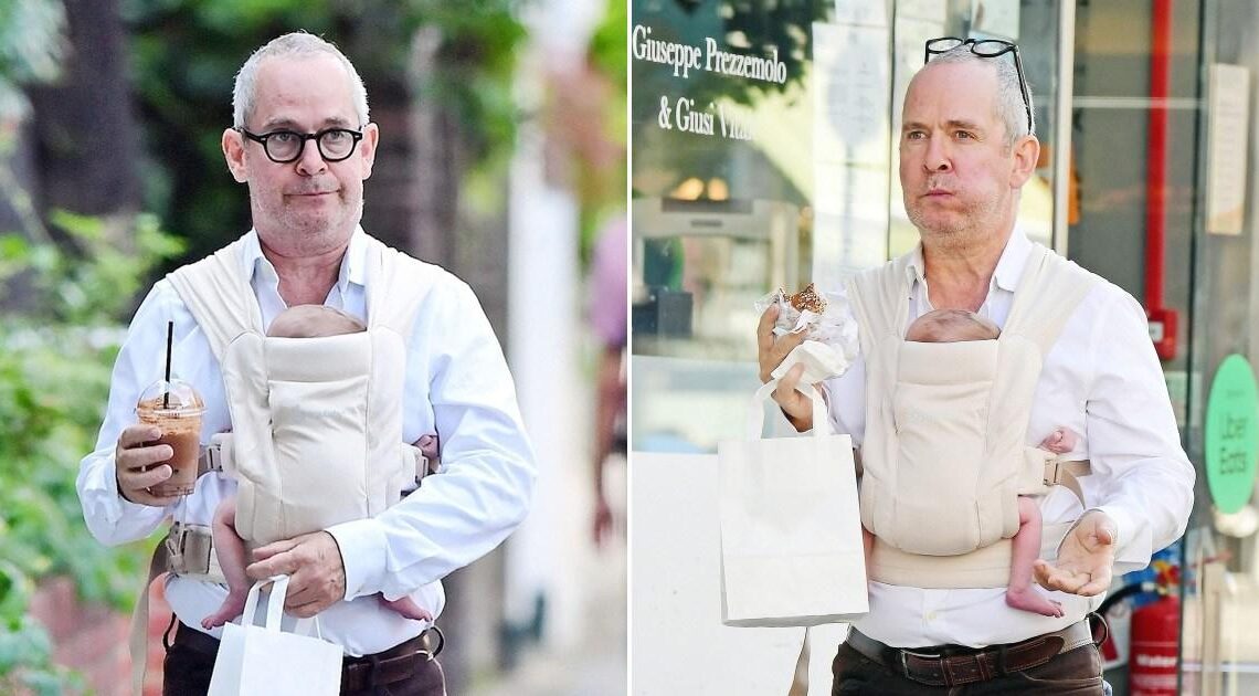 First-time dad Tom Hollander, 56, spotted with newborn strapped to his chest